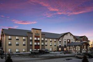 a large building with a parking lot in front of it at MainStay Suites Gaylord in Gaylord