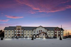 a large building with a parking lot in front of it at MainStay Suites Gaylord in Gaylord