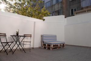 una sedia e un tavolo accanto a un muro bianco di Entrecampos - Family apartment with Terrace a Lisbona