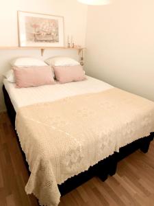 a bedroom with a bed with pink pillows at City Home Aapeli in Kuopio