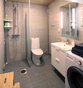 a bathroom with a toilet and a shower and a sink at City Home Aapeli in Kuopio