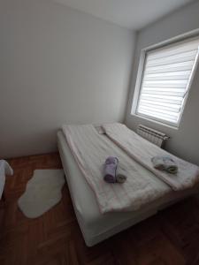 una camera da letto con un letto con un paio di scarpe sopra di Stari Cerak a Žarkovo