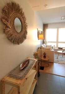 a living room with a table and a mirror on the wall at City Home Aapeli in Kuopio