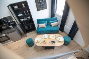 ein Wohnzimmer mit einem Sofa und einem Tisch in der Unterkunft KASA du Moulin - Cosy et au calme in Saint-Quentin