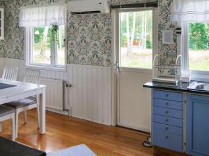 a kitchen with a desk and a table and windows at 4 person holiday home in VITTSJ in Vittsjö