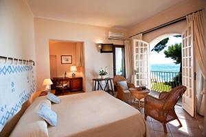 a bedroom with a bed and a view of the ocean at Is Morus Relais in Santa Margherita di Pula
