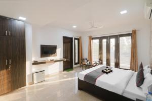 a hotel room with a bed and a tv at Hotel Green Wood By Dreamz Hospitality in Gurgaon