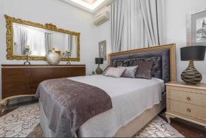 - une chambre avec un lit avec un miroir et une commode dans l'établissement Arhondiko Apartment VS Rhodes Town, à Rhodes