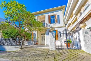 una casa blanca con una puerta y un árbol en Arhondiko Apartment VS Rhodes Town, en Rodas