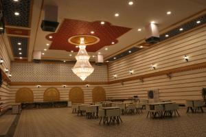 a large banquet hall with tables and a chandelier at RAJWADA RESORT & HOTEL in Raipur