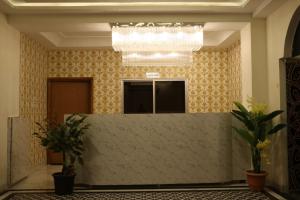 a lobby with a reception desk and a chandelier at RAJWADA RESORT & HOTEL in Raipur