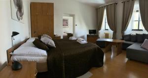 ein Schlafzimmer mit einem großen Bett und einem Sofa in der Unterkunft Hotel U Apoštola in Jevíčko