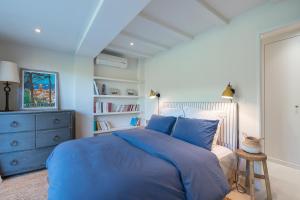聖特羅佩的住宿－LA PAUSA, Maison de ville avec Jardin centre de SAINT TROPEZ，一间卧室配有蓝色的床和蓝色梳妆台