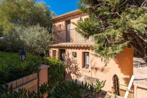 une maison avec un balcon et des arbres dans l'établissement LA PAUSA, Maison de ville avec Jardin centre de SAINT TROPEZ, à Saint-Tropez