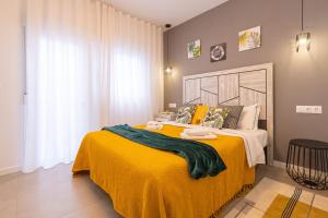 a bedroom with a large bed with a yellow blanket at PÌSO MAR ALTEA in Altea