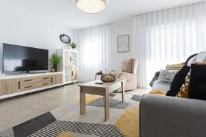 a living room with a couch and a tv at PÌSO MAR ALTEA in Altea