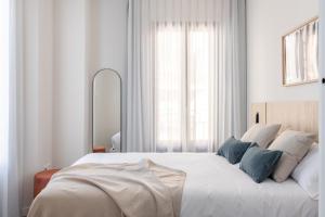 Posteľ alebo postele v izbe v ubytovaní Apartamentos Líbere Granada Catedral