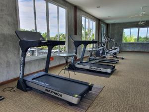 Banpu Resort Trat في ترات: صف من آلات القلب في صالة ألعاب رياضية مع نوافذ