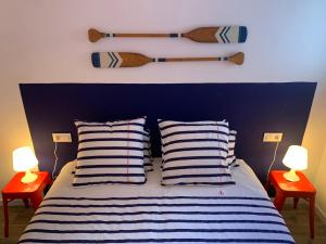 ein Schlafzimmer mit einem Bett mit zwei Lampen und zwei Baseballschlägern an der Wand in der Unterkunft CAN MARTINEZ Calella Beach Boutique Apartment in Calella