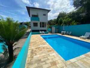 une villa avec une piscine et une maison dans l'établissement Ilhabela Casa com Piscina, à Ilhabela