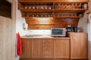 a small kitchen with wooden cabinets and a microwave at Ostoya Sulistrowiczki in Sulistrowiczki