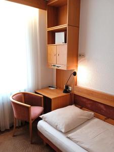 um quarto com uma cama, uma secretária e uma cadeira em Pension Müller Gartner em Groß-Enzersdorf