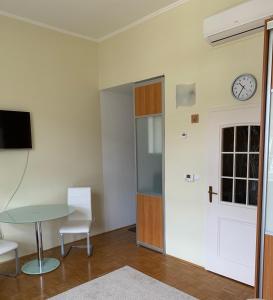 una stanza con tavolo e orologio sul muro di Apartment 19 Vila Golf Nice Vacation a Rogaška Slatina