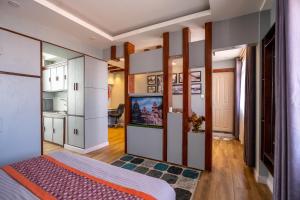 Schlafzimmer mit einem Kingsize-Bett und einem TV in der Unterkunft Times Square Apartments in Pātan