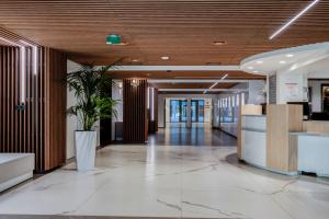 un hall de bureau avec une usine de pot au milieu dans l'établissement Hôtel Lyon Métropole, à Lyon