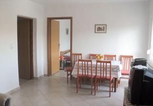 a dining room with a table and chairs at Apartments Niko - 40m from the beach in Donji Karin