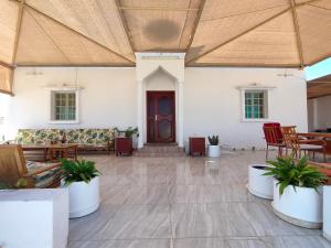 Habitación grande con mesas, sillas y puerta. en Ras Al Hadd Orchid, en Al Hadd