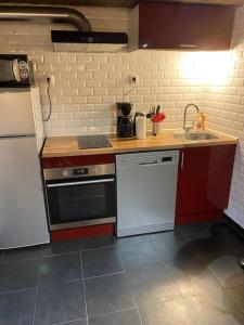 a kitchen with a white refrigerator and a sink at Studio 29 m2 proche La Défense et Arena in Nanterre