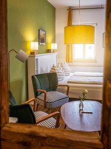 a living room with chairs and a table and a bed at Pension Onkel Ernst in Naumburg
