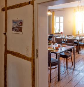 uma sala de jantar com mesa e cadeiras em Pension Onkel Ernst em Naumburg