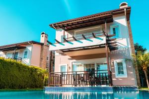 a house with a swimming pool in front of it at Aysimi Villas in Kemer