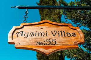 a sign that says austin villages is hanging on a tree at Aysimi Villas in Kemer