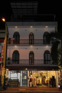 ein weißes Gebäude mit einem Balkon an der Seite in der Unterkunft Hotel Decentraland Kuala Terengganu in Kuala Terengganu