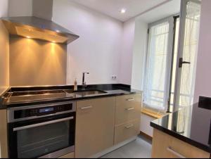 a kitchen with a sink and a stove at Au cœur de Cauterets, joli duplex de 55m² in Cauterets