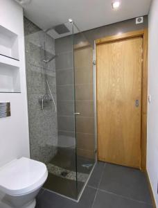 a bathroom with a shower with a toilet and a glass door at Au cœur de Cauterets, joli duplex de 55m² in Cauterets