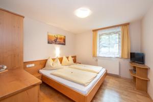- une chambre avec un lit et une télévision dans l'établissement Landhaus Nagl, à Altenmarkt im Pongau