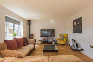 a living room with a couch and a tv at The George - Large family home by the sea in Deal