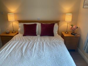 a bedroom with a bed with two lamps on two tables at Village Way Apartments in Kincasslagh