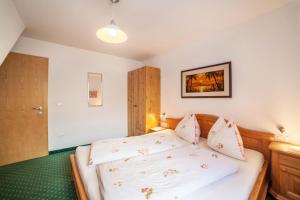 a bedroom with a bed with white sheets at Roath Hof Ferienwohnung 2 in Schenna +16 photos