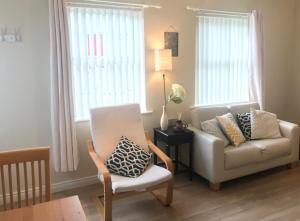 a living room with a couch and a chair at Village Way Apartments in Kincasslagh