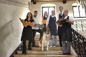 a group of people standing on the stairs with a dog at Grand Hôtel de l'Abbaye in Beaugency