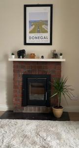 a living room with a brick fireplace with a shelf at Village Way Apartments in Kincasslagh