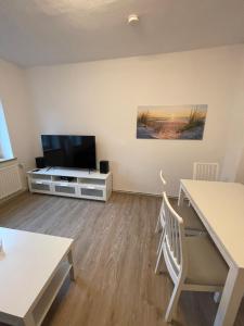 a living room with a flat screen tv and a table at strandnahe 3-Zimmer Wohnung direkt am Yachthafen in Kiel