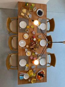 a table with plates and bowls of food on it at Urban Mountain Chalet with Lake View in Maurach