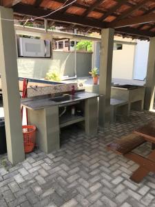 eine Terrasse mit einem Tisch und einer Mikrowelle in der Unterkunft Suites em Maresias in Maresias