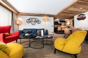 salon z żółtymi krzesłami i niebieską kanapą w obiekcie Vail Lodge by Alpine Residences w mieście Val dʼIsère
